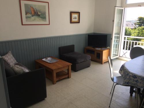 un salon avec un canapé, une table et une télévision dans l'établissement Le Dolmen, à La Celle-sous-Gouzon