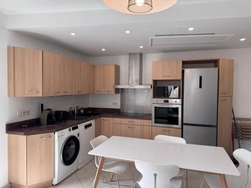 - une cuisine avec une table blanche et des appareils électroménagers blancs dans l'établissement Beau 4 pièces - hyper centre 8 couchages, à Nice