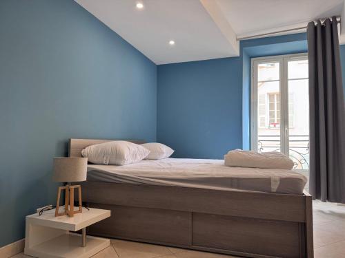 une chambre avec un mur bleu et un lit dans l'établissement Beau 4 pièces - hyper centre 8 couchages, à Nice