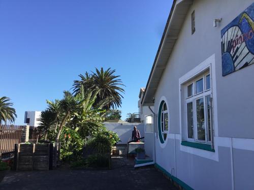 a person sitting on a table outside of a building at Pianoforte holiday apartments in Swakopmund