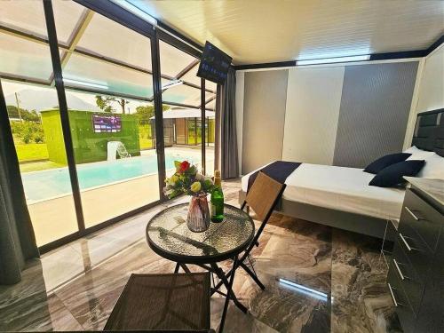 a bedroom with a bed and a table and a pool at Casa Cristal # 1 in Fortuna