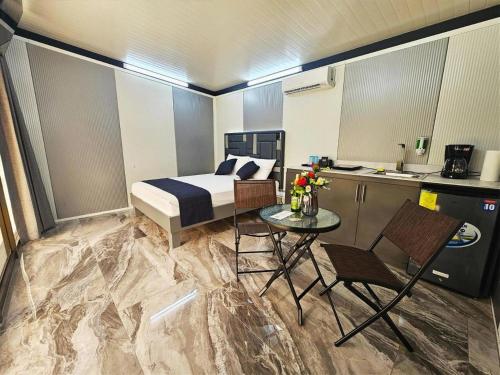 a bedroom with a bed and a table and a kitchen at Casa Cristal # 1 in Fortuna