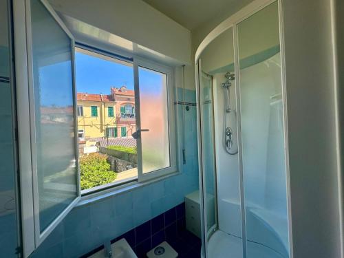 a bathroom with a glass shower and a window at Villa Marcellina - Piazza San Giovanni, Giardino Privato, Jacuzzi e Barbecue in Loano