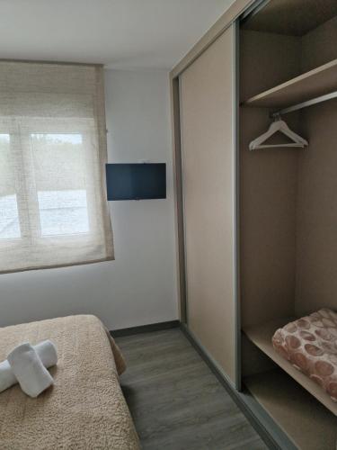 a bedroom with a bed and a window and a mirror at Apartamento Calma in Negreira