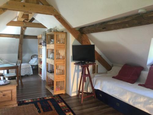 Cette chambre mansardée comprend 2 lits et une télévision. dans l'établissement La Campagne à la Mer, proche d'Etretat, à Angerville-la-Martel