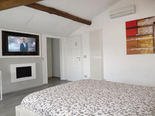a bedroom with a bed and a tv on the wall at H5-5H Luxury Room in Maranello