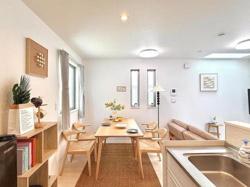 a kitchen and living room with a table and a couch at Yodamari House Ikebukuro Direct access to Shinjuku and Shibuya7 people OK! in Tokyo