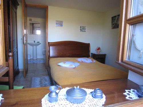 - une chambre avec un lit et une table avec de la vaisselle dans l'établissement Gîte Les Places avec piscine, à La Celle-sous-Gouzon