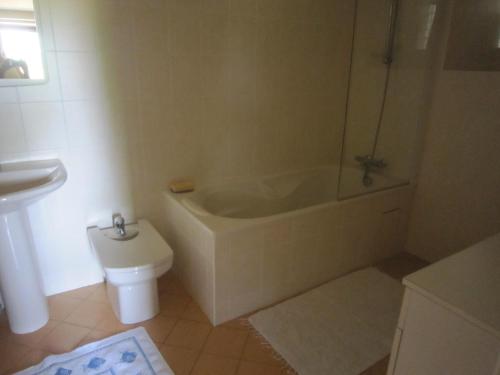 une salle de bain avec une baignoire, des toilettes et un lavabo dans l'établissement Gîte Les Places avec piscine, à La Celle-sous-Gouzon