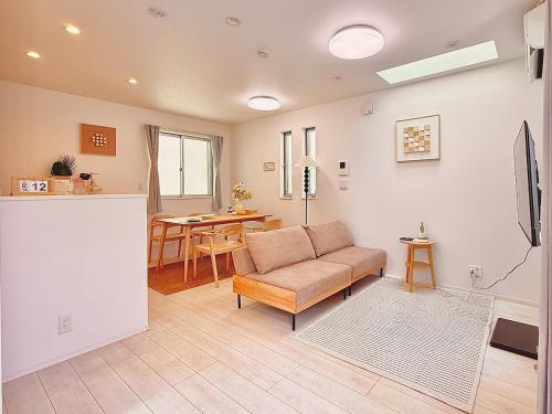 a living room with a couch and a table at Yodamari House Ikebukuro Direct access to Shinjuku and Shibuya7 people OK! in Tokyo