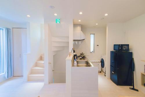 a kitchen with a black refrigerator and a sink at Yodamari House Ikebukuro Direct access to Shinjuku and Shibuya7 people OK! in Tokyo