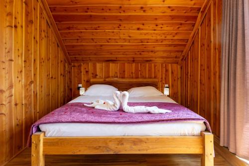 a wooden bed with two people laying on it at Villa Harmonia Private Jacuzzi and Pool Retreat near Rogaška in Rogatec