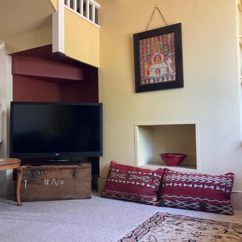 a living room with a flat screen tv and a couch at Terraced Garden House Three Bedrooms in Stamford