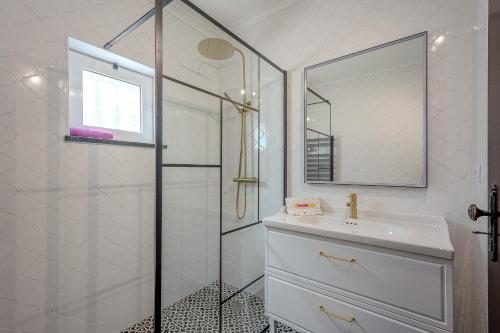 a bathroom with a shower and a sink and a mirror at Villa Amendoeira-POOL HEATED - By Algarkasa in Guia
