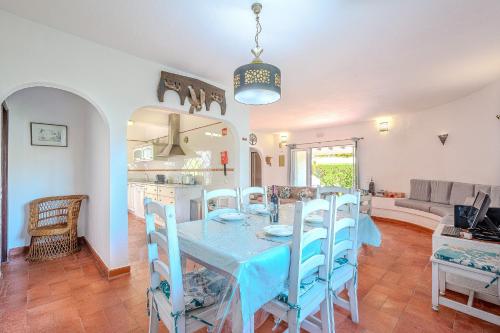 a kitchen and dining room with a blue table and chairs at Villa Amendoeira-POOL HEATED - By Algarkasa in Guia
