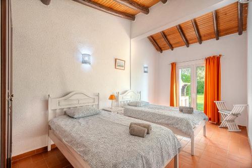 a bedroom with two beds and a window at Villa Amendoeira-POOL HEATED - By Algarkasa in Guia