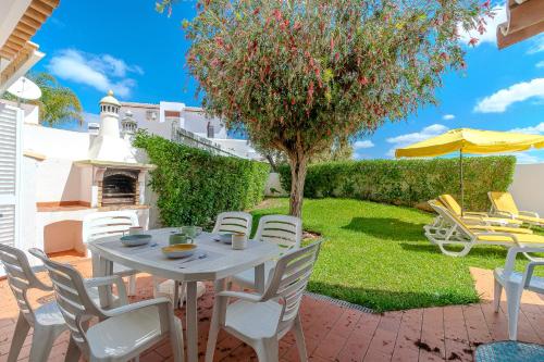 a patio with a table and chairs and a tree at Villa Amendoeira-POOL HEATED - By Algarkasa in Guia