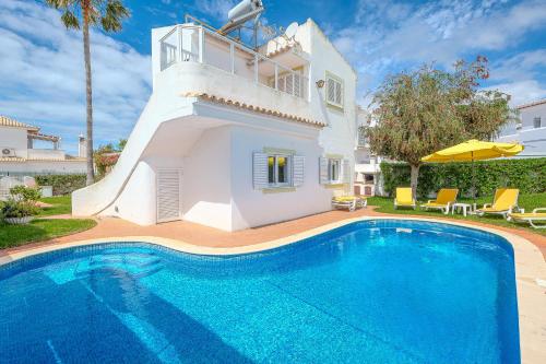 a villa with a swimming pool and a house at Villa Amendoeira-POOL HEATED - By Algarkasa in Guia