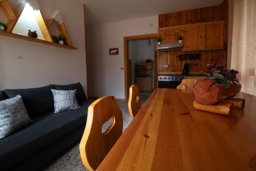 a living room with a wooden table and a blue couch at Chalet Del Rio in Fiumalbo