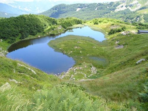 two lakes on a hillside with grass and trees at Chalet Del Rio in Fiumalbo