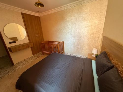 a bedroom with a bed and a mirror at Julie Airport Marrakech Apartments in Marrakech