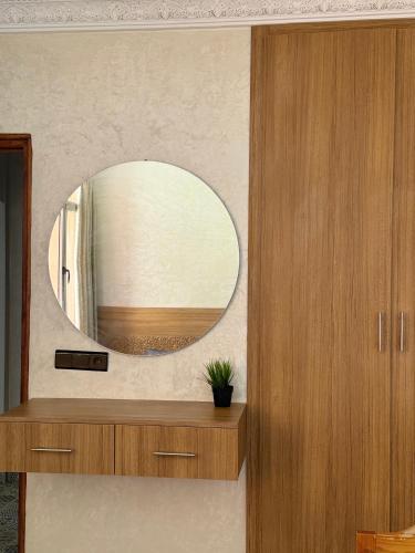 a bathroom with a circular mirror on a wall at Julie Airport Marrakech Apartments in Marrakech