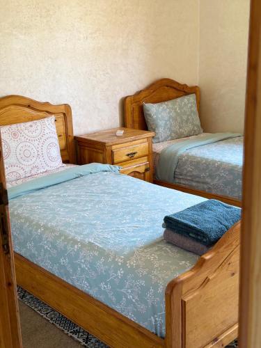 a bedroom with two beds and a night stand at Julie Airport Marrakech Apartments in Marrakech