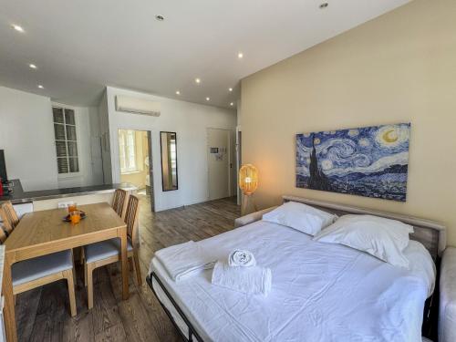 - une chambre avec un lit, une table et un tableau dans l'établissement Forville Market View, à Cannes