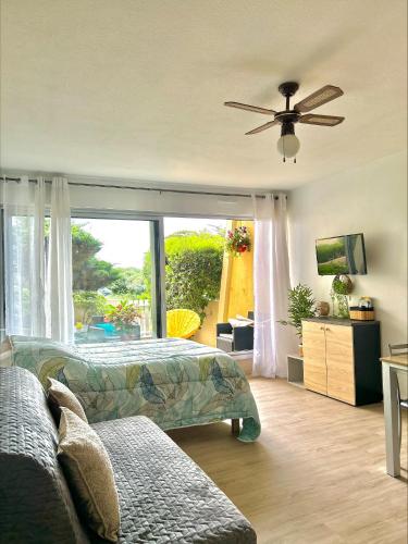 une chambre avec un lit et un ventilateur de plafond dans l'établissement Studio cosy à 1mn de la mer, jardin et parking privé, à Saint-Jean-de-Monts