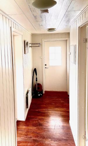 an empty hallway with wood floors and a door at Between fjord and mountain in Svolvær