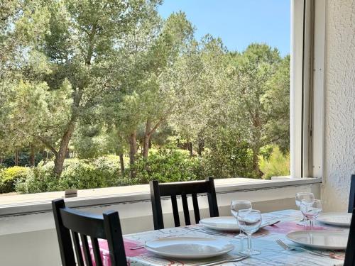 une table avec quatre chaises et une vue sur une fenêtre dans l'établissement Studio Cozy - Loggia - Plage 200m, à La Seyne-sur-Mer