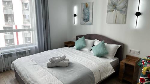 a bedroom with a bed with two towels on it at Флора in Almaty