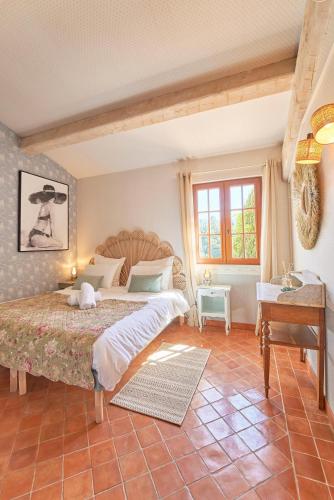 une chambre avec un grand lit et une table dans l'établissement Charme provençal Les amandiers piscine et animaux, à Solliès-Toucas