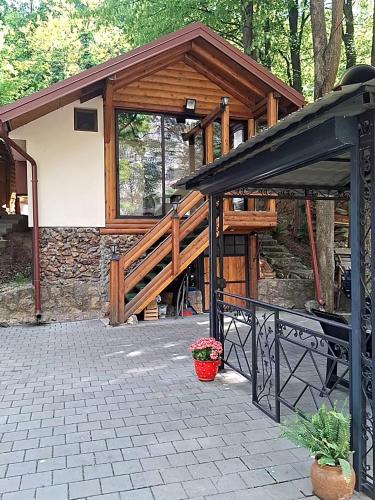 a pavilion with a deck and a building at Moravski konak- Moravian Inn in Ovčar Banja