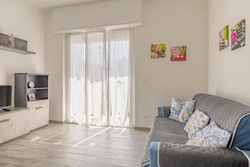 a living room with a couch and a television at Loano Top Flat in Loano