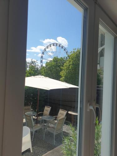 a patio with a table and chairs and a ferris wheel at Várfürdő apartman in Gyula