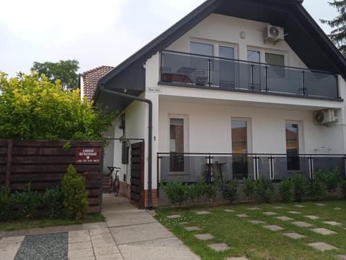 a white house with a black roof at Várfürdő apartman in Gyula