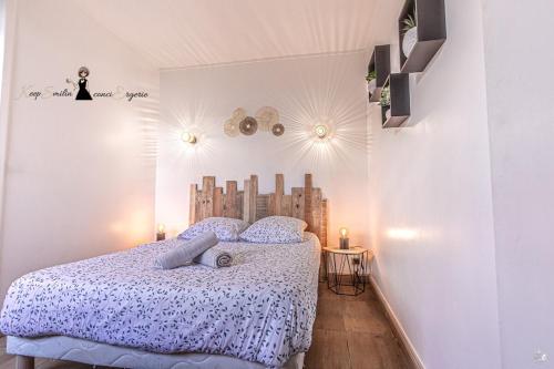une chambre avec un lit avec une tête de lit en bois dans l'établissement Le Bohème chic et cosy au cœur de Pau, à Pau