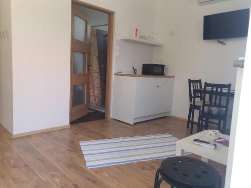 a living room with a kitchen and a table and chairs at Várfürdő apartman in Gyula