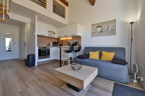 un salon avec un canapé bleu et une table dans l'établissement Chez Marie-Thé, à Sausset-les-Pins