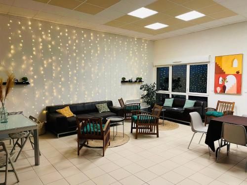 a waiting room with couches and tables and chairs at Chalet dans le Perche in Soligny-la-Trappe
