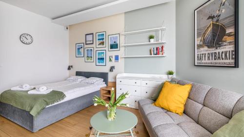a living room with a couch and a bed at Marina Kąty Rybackie Apartamenty PIAMOLA in Kąty Rybackie