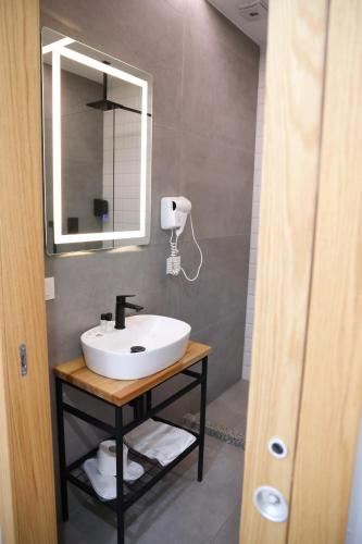 a bathroom with a sink and a mirror at Sol Hotel in Shkodër