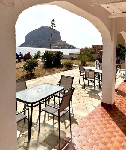 a patio with tables and chairs and a view of the water at Villa Diamanti in Monemvasia