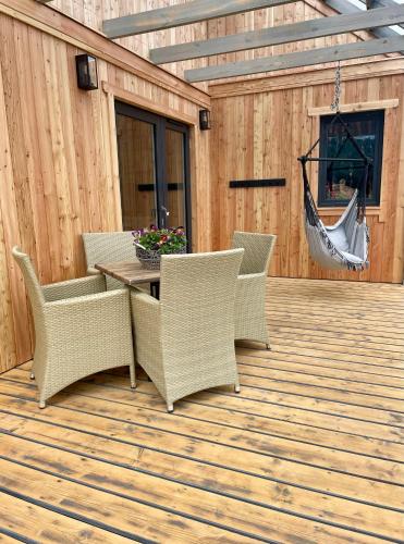 a patio with a table and chairs on a wooden deck at Somnium Pieniny in Tylka