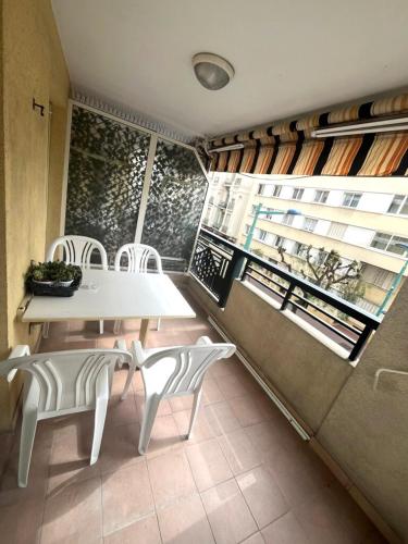 une salle à manger avec une table et des chaises blanches dans l'établissement Menton center 200 m from the sea, terrace and garage, à Menton