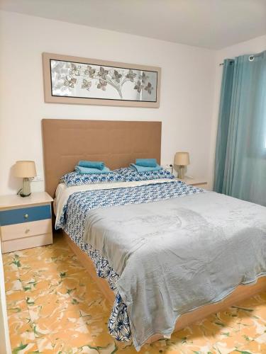 a bedroom with a bed with blue pillows on it at Desigual apartamento con 3 AC in Gandía