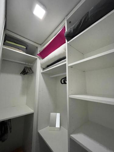 - un dressing avec étagères blanches et tiroir dans l'établissement Charmant 2 pièces proche Croisette, à Cannes