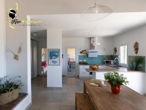 a kitchen with a wooden table in a room at Villa Acciagina 10 pers PISCINE VUE MER PINARELLO Climatisée in Pinarellu
