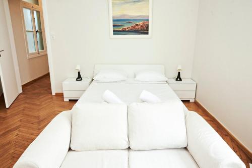 アテネにあるPerikleous Estateの白い部屋にベッドが2つある白いソファ